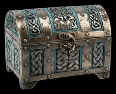 an old metal chest with blue and white designs on the top, sitting in front of a black background