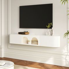 a flat screen tv mounted to the side of a white wall in a living room