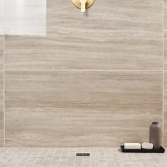 a white tiled bathroom with a gold faucet and soap dispenser