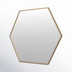 a mirror that is on the wall with a white surface and gold trim around it