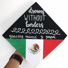 a hand holding a black and white graduation cap with the words dreams without borders on it