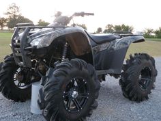 a large four - wheeler is parked on the gravel