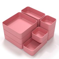 a pink set of four square trays on a white surface with the lids down