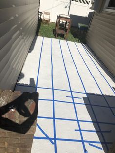 the back yard has been painted with blue tape and is ready to be used as a patio