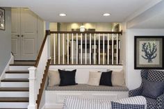 a living room filled with furniture next to a stair case in a home's entryway