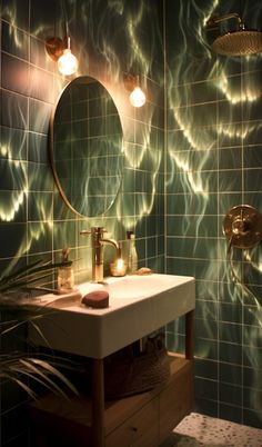 a bathroom with green tiles and lights on the wall