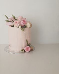 there is a pink cake with flowers on it