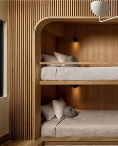 two bunk beds in a room with wood paneling and white pillows on the floor