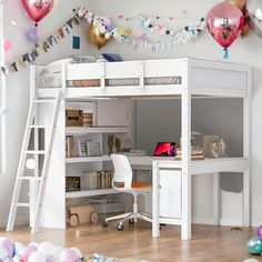 there is a loft bed with a desk underneath it and balloons all over the room