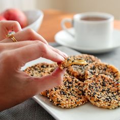 a person is eating sesame seed bagels on a plate