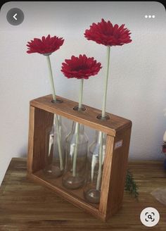 three vases with flowers in them sitting on a table