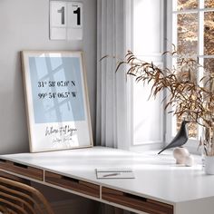 an office desk with a plant in the corner and a poster hanging on the wall