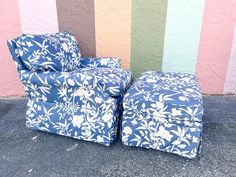 two blue chairs sitting next to each other in front of a colorful wall