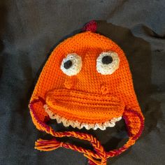 an orange knitted hat with googly eyes