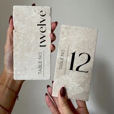 two women holding up some type of stone with numbers on it and the number twelve