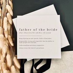 two white envelopes with the words father of the bride printed on them next to some dried grass