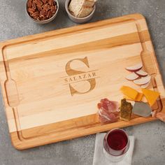 a personalized cutting board with cheese, meats and nuts on the counter top