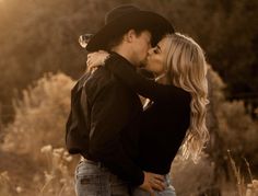 a man and woman kissing each other in a field