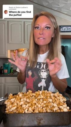 a woman holding her hands up in front of a pan full of food with the words, where do you find my popcorn?