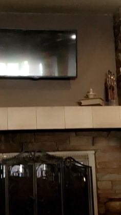 a flat screen tv mounted above a fireplace