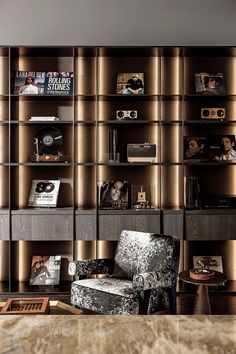 a living room filled with furniture and bookshelves next to a wall covered in shelves