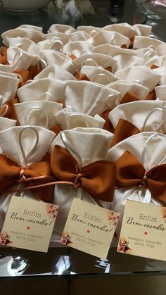 the table is covered with white and orange napkins that have brown bows on them