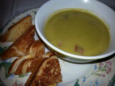 a bowl of soup and some grilled bread on a plate