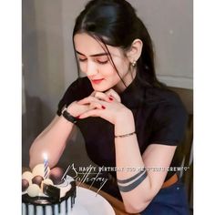 a woman sitting in front of a cake with candles on it