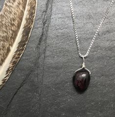 Protection Stone Necklace, Gemstone Protection Jewelry, Garnet Necklace, Empath Protection Gemstone Jewelry This unique handmade, crystal gemstone necklace is a wonderful addition to any wardrobe. This deep red, gemstone pendant is an all natural Garnet nugget with unique textures. The gemstone is wire wrapped in genuine sterling silver and is carried by a box style chain. A spring ring clasp secures the chain. All together creating a perfect necklace for everyday wear. About the Gemstone: Garne Red Gemstone Pendant Crystal Necklaces, Red Pendant Crystal Necklaces With Gemstone, Red Gemstone Pendant Crystal Necklace, Garnet Gemstone Beads Jewelry As A Gift, Garnet Gemstone Beads Jewelry For Gifts, Spiritual Garnet Gemstone Necklace, Red Crystal Pendant Necklace With Natural Stones, Teardrop Gemstone Pendant For Jewelry Making, Red Crystal Pendant Necklaces