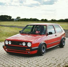 a red car parked on top of a brick road