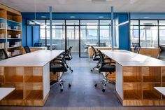 an empty office with desks, chairs and bookshelves