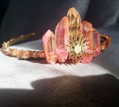 "Our Aurora sun goddess headpiece is a stunner with its two tone sunset inspired quartz crystals surrounded by hand beaded sunstone gemstones. Our boho quartz crystal headband is perfect for boho Beach weddings, festivals and more! - 15\" inch open circumference - Golden brass headband base - Dyed Quartz crystals - Sunstone tumbled gemstones - Golden brass sun charm with faux pearl inlay - Golden brass wire wrapping - Every crown is a one of a kind due to the natural state of the crystals and ge Quartz Crown, Pink Aura Quartz, Goddess Crown, Raw Quartz Crystal, Pink Aura, Crystal Headpiece, Aura Crystals, Different Shades Of Pink, Raw Quartz