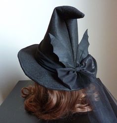 a woman's head wearing a black witches hat