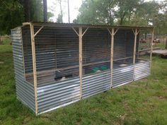 an outdoor chicken coop in the middle of a field with a video playing on it