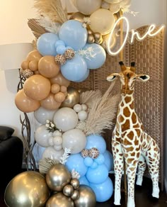 a giraffe is standing next to balloons and other decorations