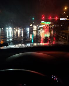 the dashboard of a car at night with traffic lights