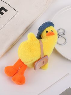 a yellow stuffed duck with a hat on it's head sitting next to a pair of scissors