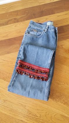 a pair of jeans sitting on top of a wooden floor