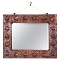 a mirror hanging on a wall with metal balls