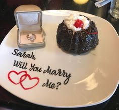 a white plate topped with a piece of cake next to a ring on top of it