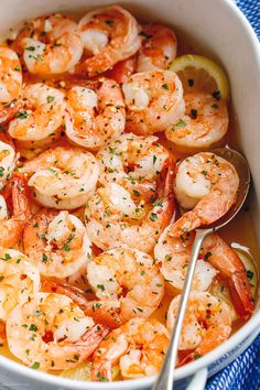 a white bowl filled with shrimp and lemon