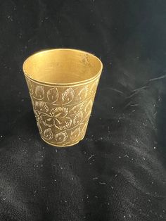 a gold cup sitting on top of a black cloth