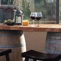 two wine glasses sitting on top of wooden barrels