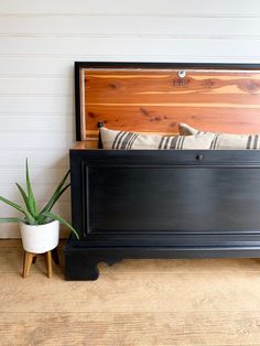 a bed with a wooden headboard and foot board next to a potted plant