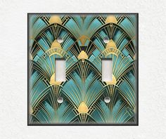 an art deco light switch plate cover in blue and gold with two lights on each side