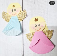 two paper angel cut outs sitting next to each other