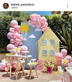 an outdoor party with balloons, tables and chairs in front of a house shaped like a sun