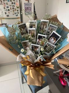 a bouquet of flowers with pictures on the side and ribbons tied around it, sitting on a table