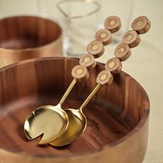 two wooden bowls with gold spoons on them