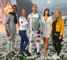 three women and two men posing for a photo with a soccer trophy in front of them